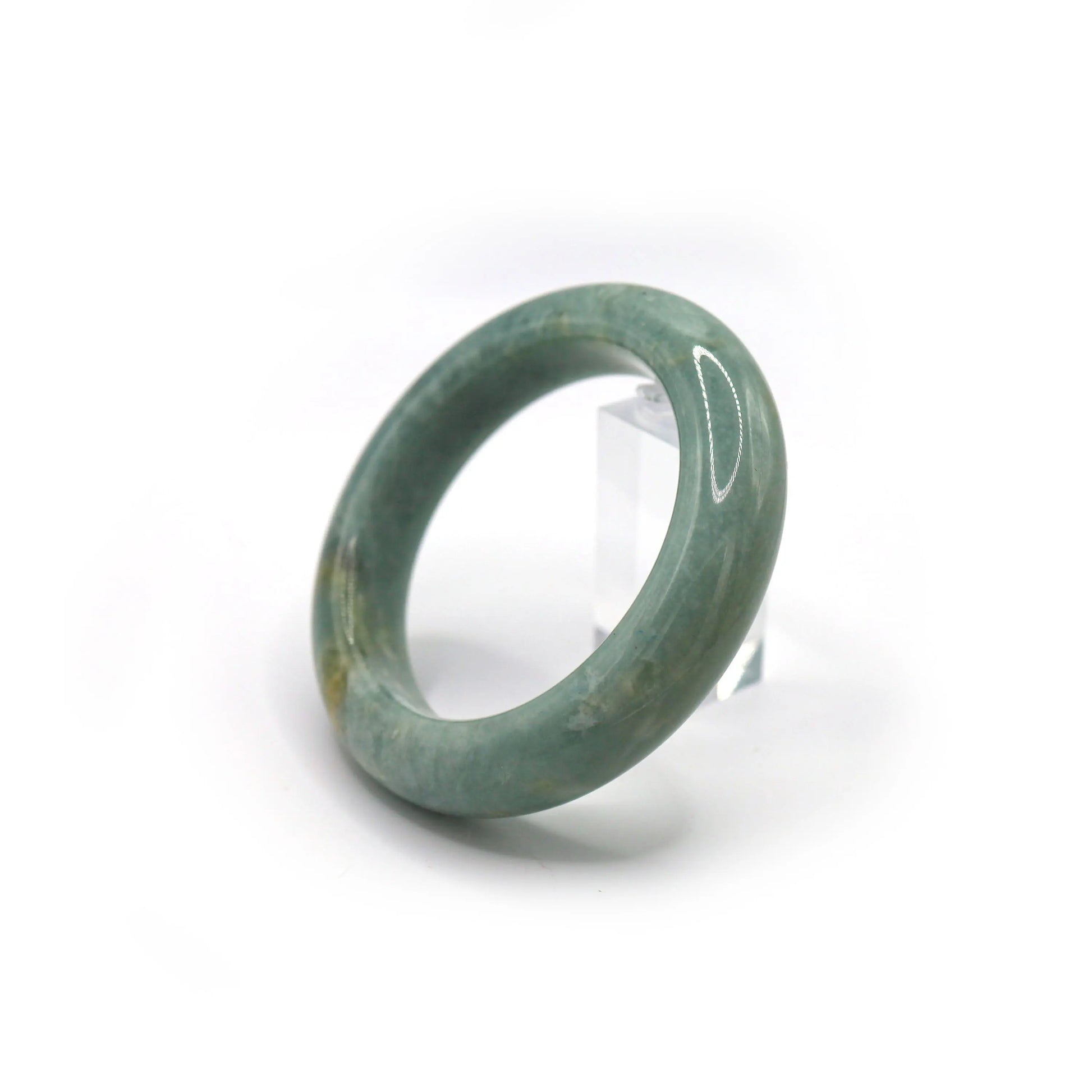 Light blue jade bangle placed in a jewelry pouch, hinting at soft color variations Miruzi