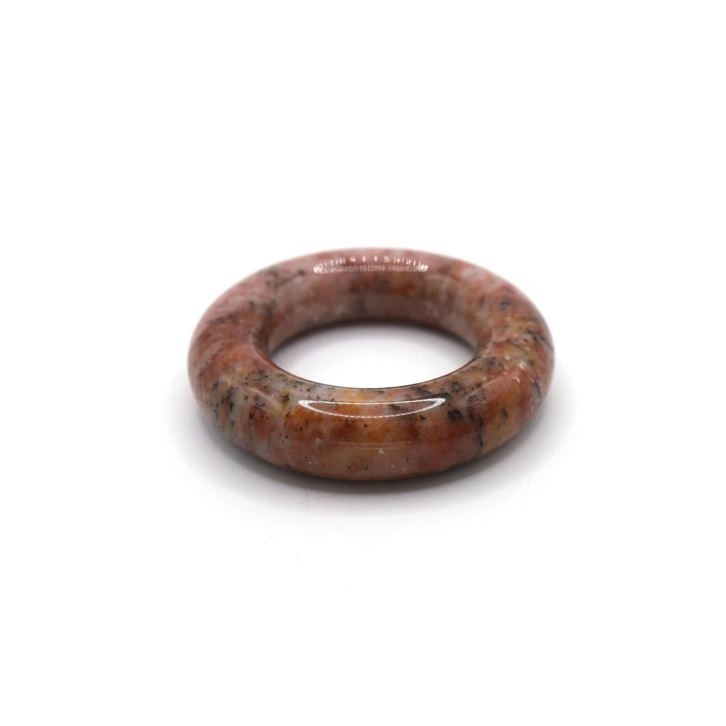 Jade bangle with soft pink tone and striking organic inclusions, styled on a neutral surface to emphasize texture and hue – Miruzi
