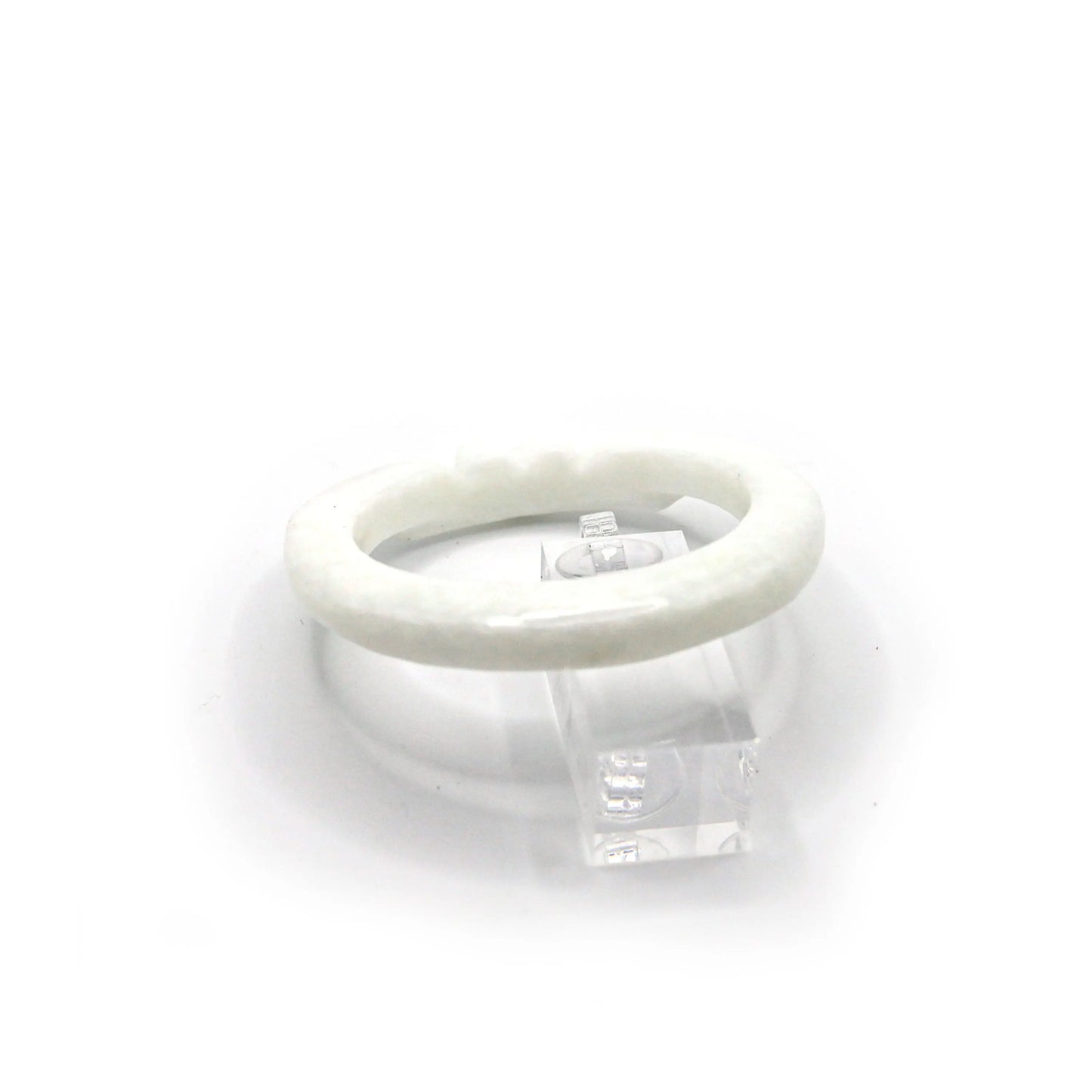 White jade bangle with clean lines and gentle engraving, resting on a blush-toned fabric to enhance its luminous softness – Miruzi
