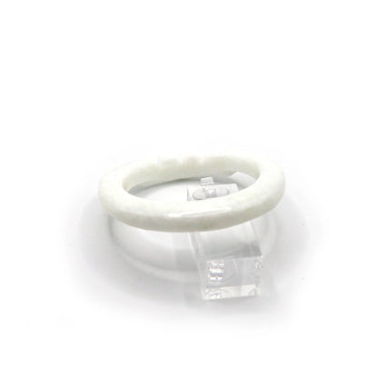 White jade bangle with clean lines and gentle engraving, resting on a blush-toned fabric to enhance its luminous softness – Miruzi