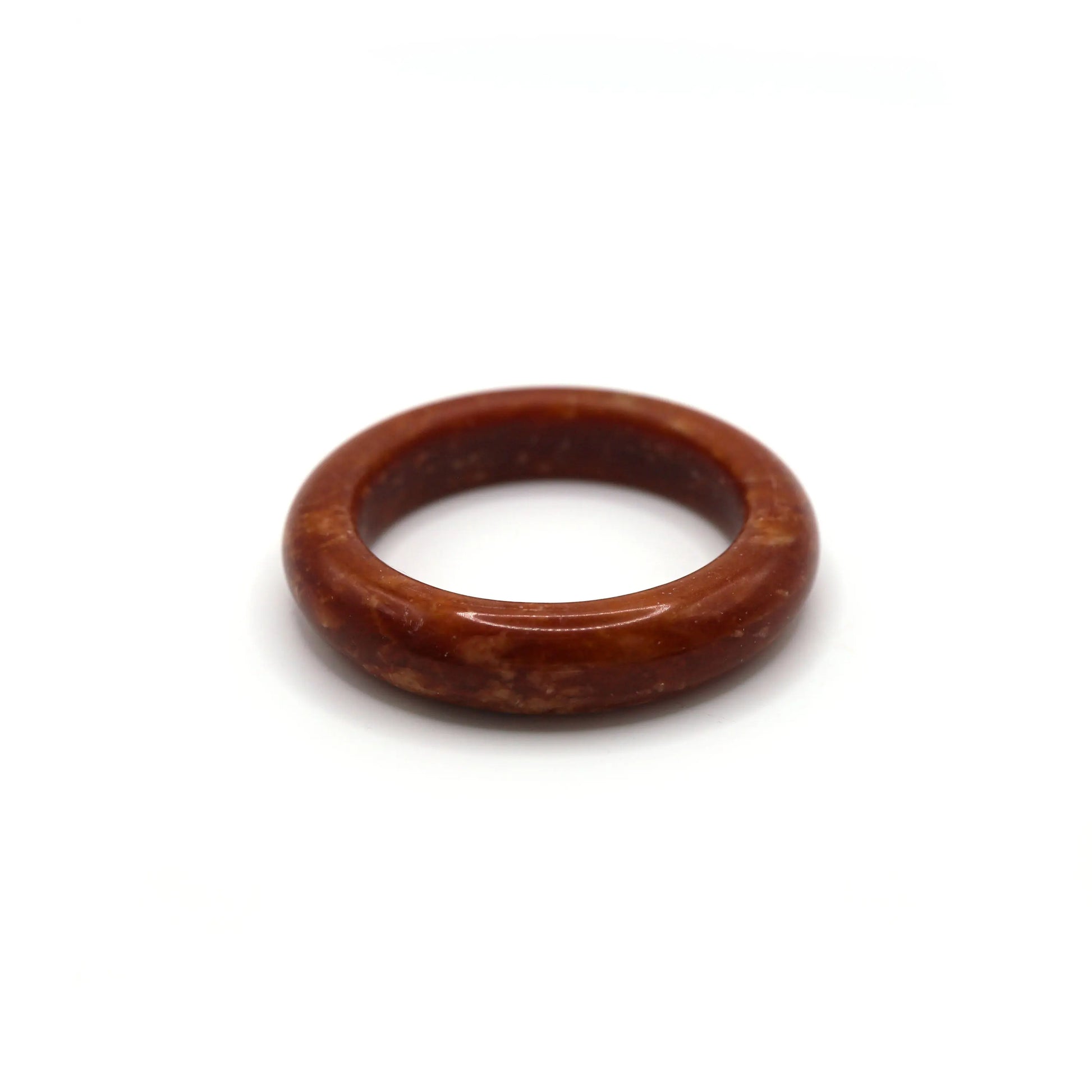 Woman wearing red jade bangle styled with neutral-toned linen outfit