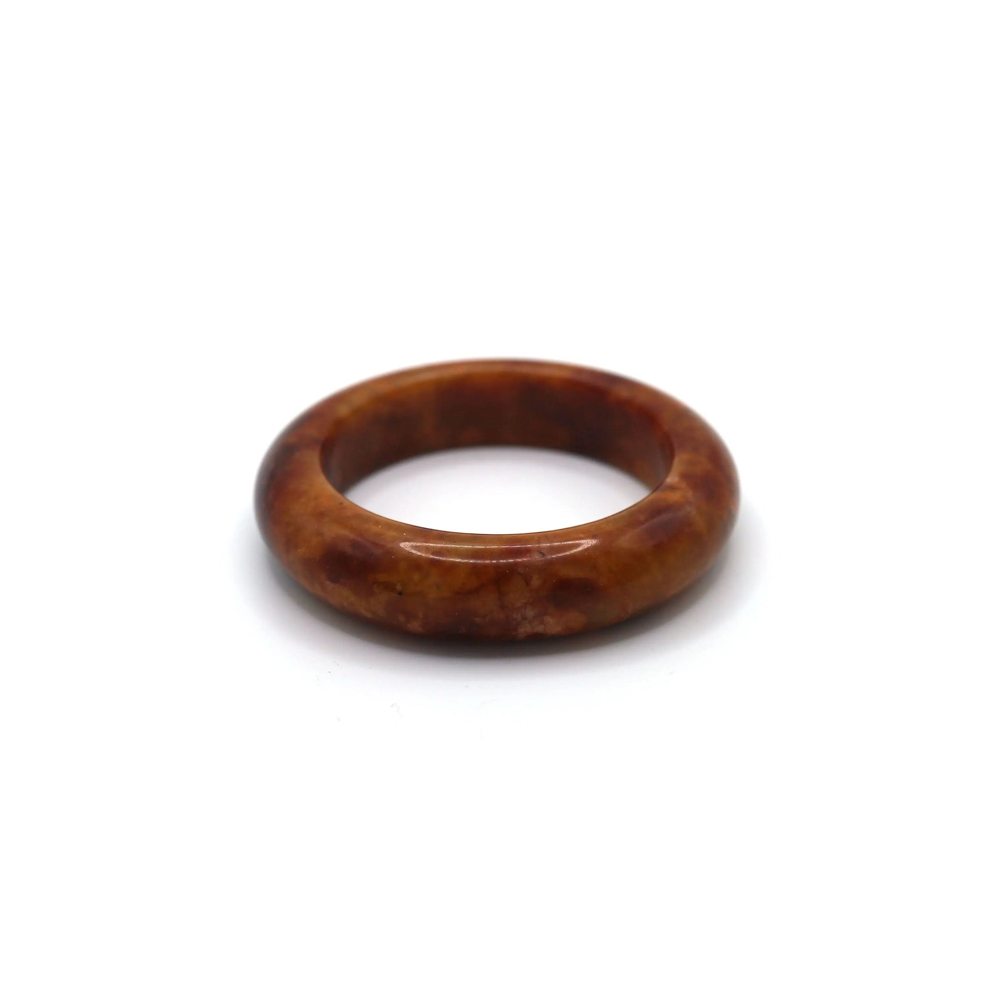 Deep red jade bracelet with soft golden and ivory veining placed on neutral background Miruzi