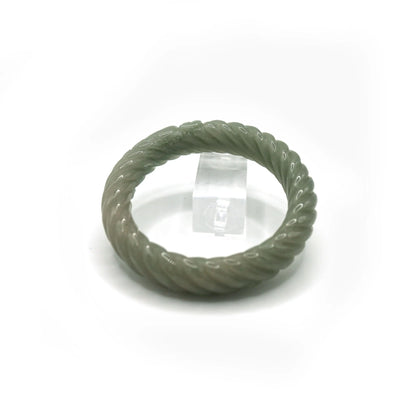 Jade bangle with full-circle twisting motion, crafted in pale green quartzite and adorned with miniature ingot carvings – Miruzi