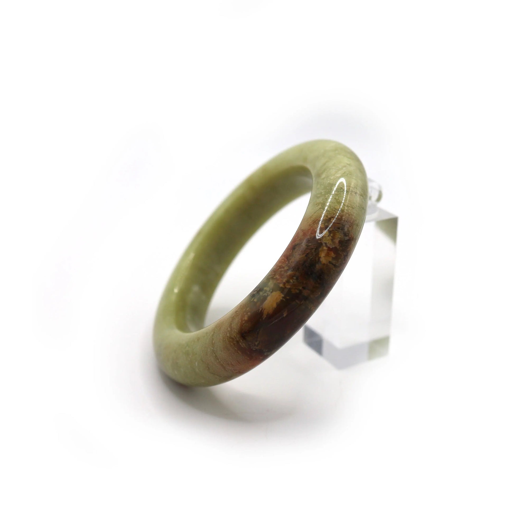Close-up of jade bracelet showing red-brown mineral vein in soft green stone Miruzi