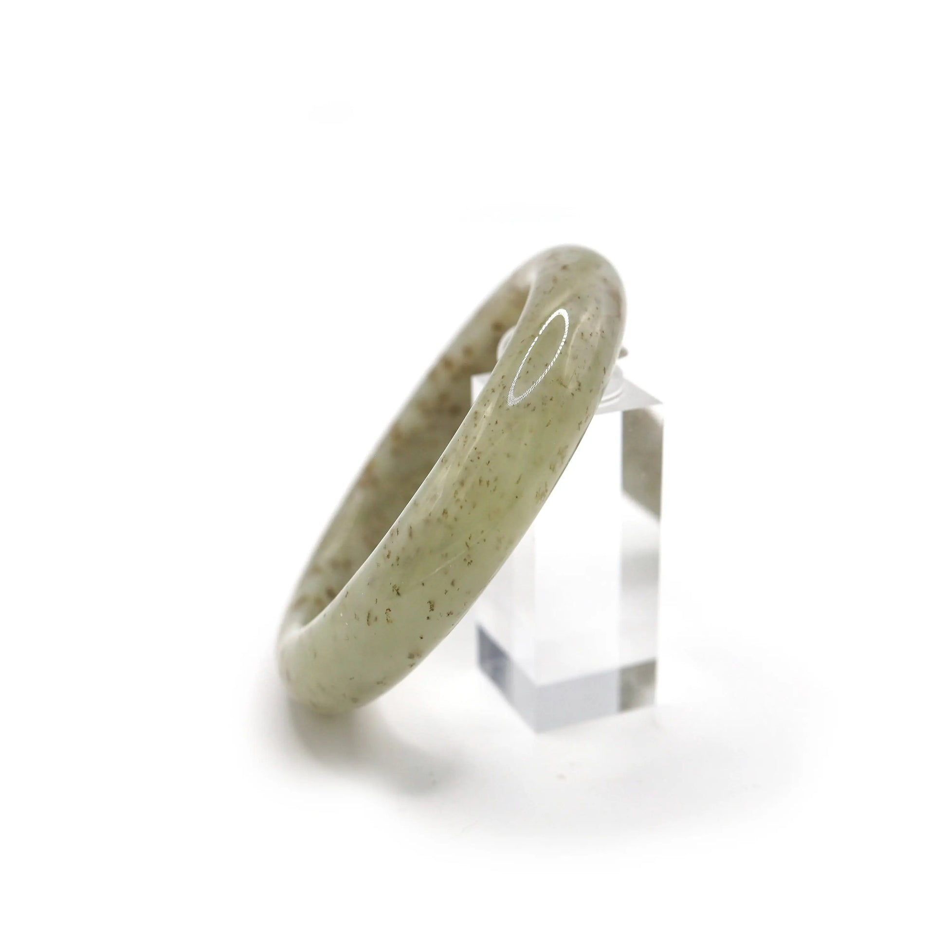 Elegant jade bracelet on neutral backdrop, featuring a clean beige hue with scattered botanical-like mineral flecks – Miruzi