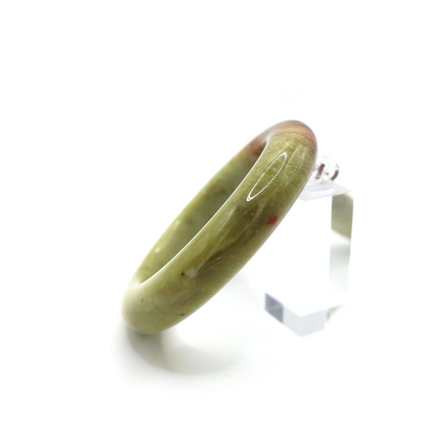 Female wrist wearing green jade bangle showing hidden red-brown patch Miruzi