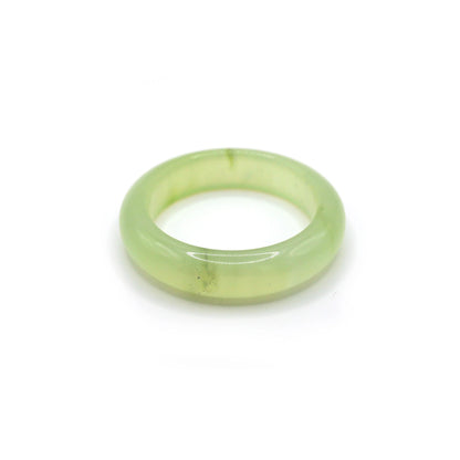 Light green jade bangle glowing softly under daylight, with no visible inclusions and a smooth, liquid-like finish – Miruzi