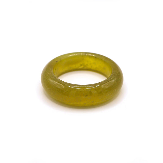 Close-up of a transparent yellow jade bangle with natural air bubbles, resembling sparkling beer in sunlight. - Miruzi