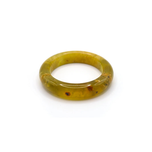 A delicate yellow jade bangle with ice-clear translucence and soft organic veining, styled on natural linen for an elegant presentation. -  Miruzi