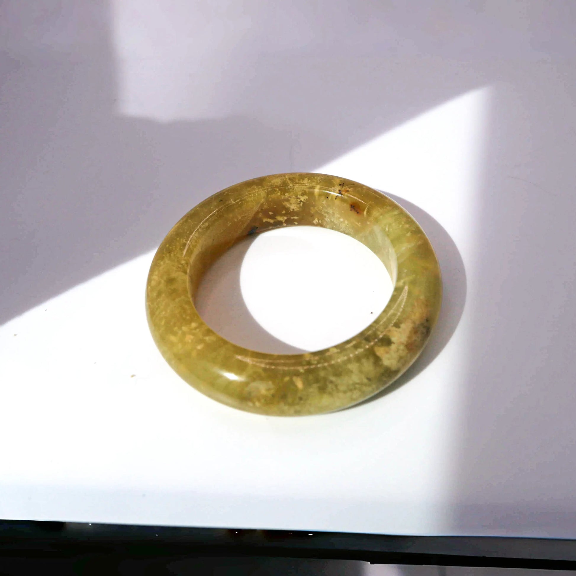 Yellow jade bracelet with natural grass-like mineral inclusions, evoking sunlight through water

