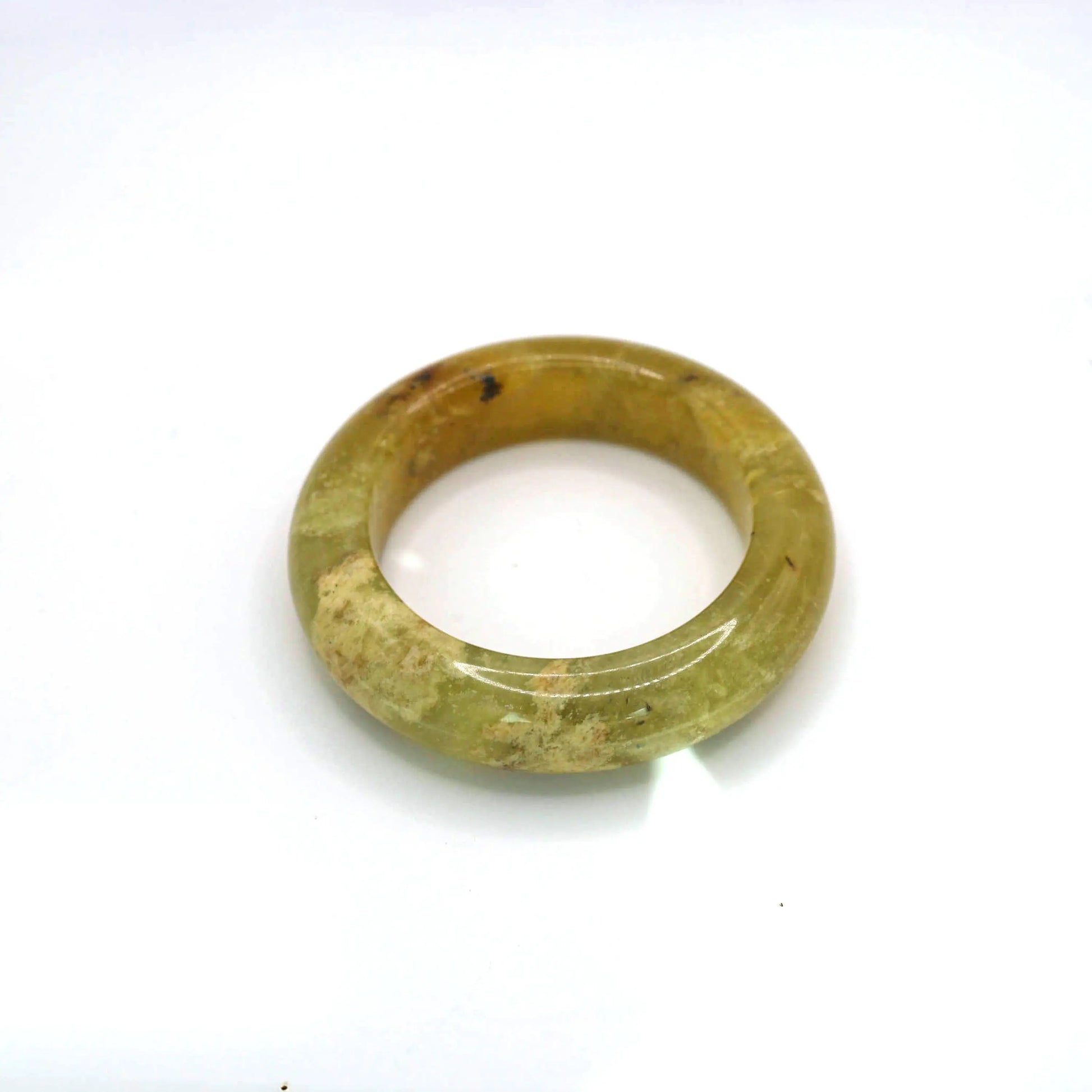 Hand-carved jade bangle featuring ice-like golden hue and softly layered mineral textures

