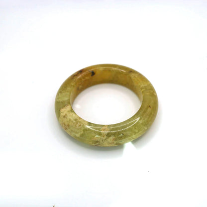 Hand-carved jade bangle featuring ice-like golden hue and softly layered mineral textures

