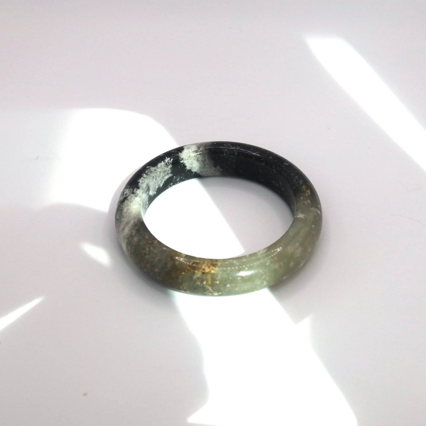 Abstractly patterned ink jade bracelet with soft visual contrast and snowflake-like mineral textures

