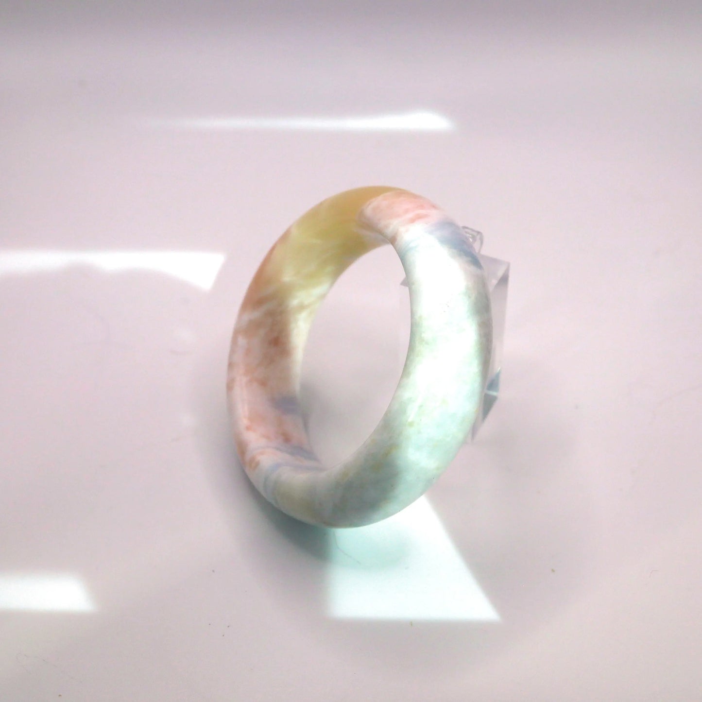 Pastel marbled jade bracelet featuring soft cloud-like patterns and a smooth, classic round silhouette

