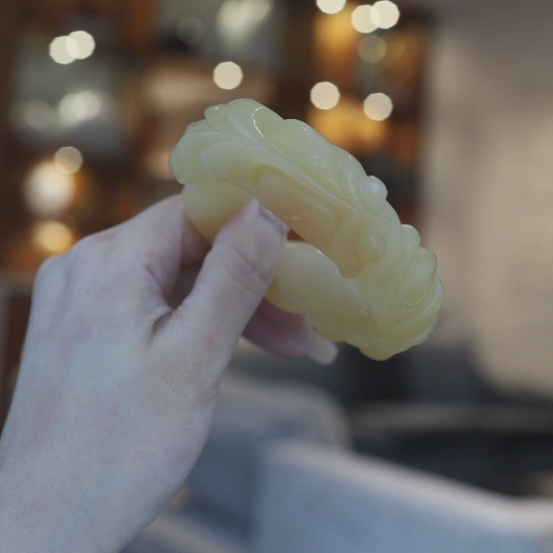 Hand-carved yellow jade bracelet featuring detailed goldfish and lotus motifs in high relief, symbolizing abundance, harmony, and natural flow – Miruzi

