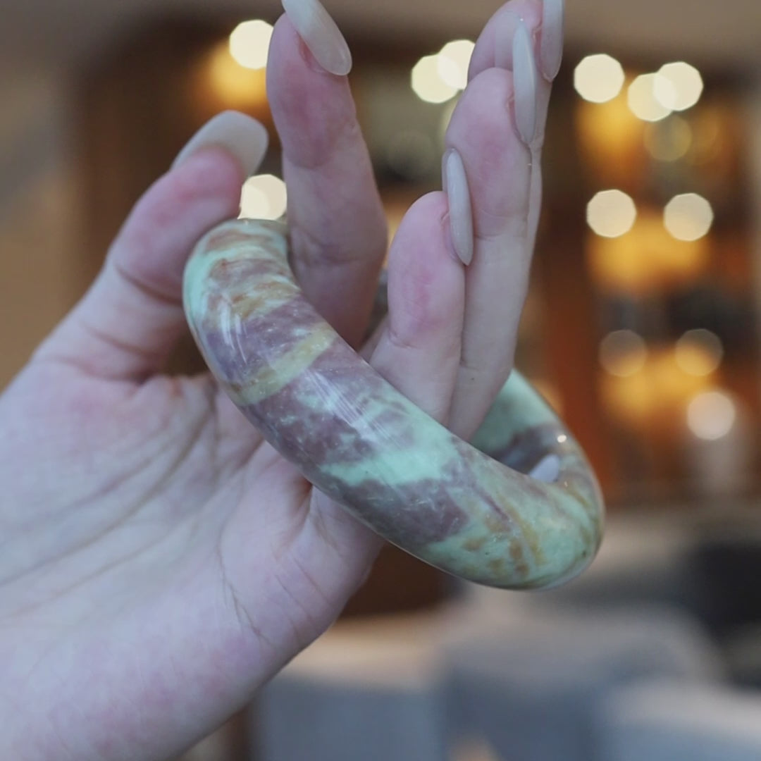Unique multi-color jade bangle featuring marbled bands and misty transitions in green, pink, and terracotta, each angle revealing new depth – Miruzi