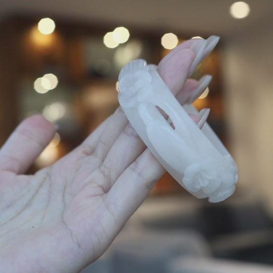 Delicate white jade bangle with five sculpted openwork violets, symbolizing renewal, purity, and blooming feminine energy – Miruzi