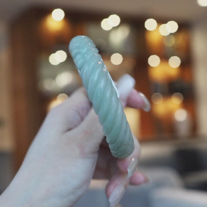 Hand-carved Mongolian green jade bangle featuring a continuous spiral twist and two subtle Yuanbao ingot carvings for prosperity – Miruzi